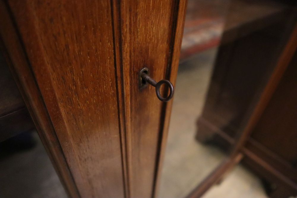 A late Victorian walnut two door glazed bookcase, width 102cm, depth 28cm, height 128cm